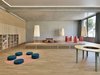 Auch die Aula mit Podest und unterschiedlichstem Mobiliar bietet viele Nutzungsmöglichkeiten.