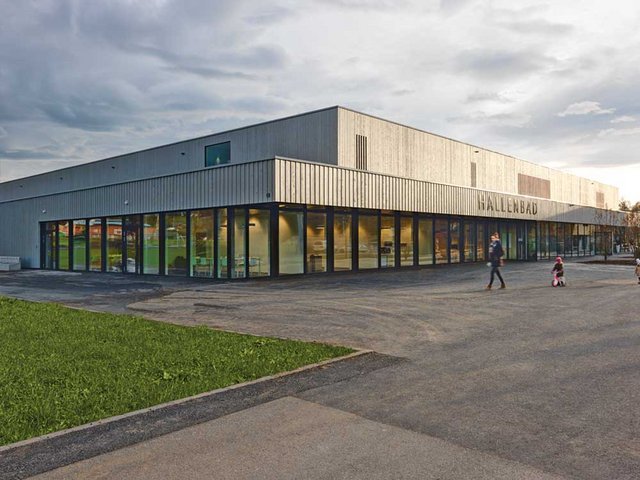 Die silbrige Holzfassade ist das Einzige, was beim Hallenbad Uster noch auf den Einsatz von Holz hinweist. Die hölzerne Tragstruktur ist nicht mehr sichtbar.