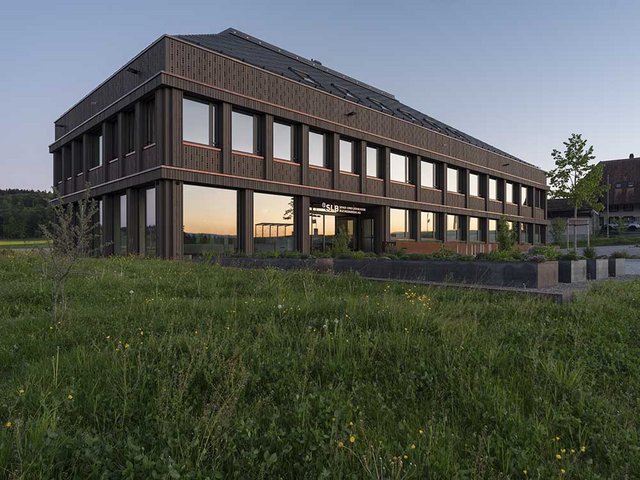 Obstwiesen und Landwirtschaftsflächen umspielen den neuen Firmenhauptsitz der Spar- und Leihkasse Bucheggberg in Lüterswil. Die Bauherrschaft legte hier grossen Wert darauf, Unternehmen aus der Region zusammenzubringen – so auch fünf Holzbauunternehmen, die dann als ARGE zusammenspannten.